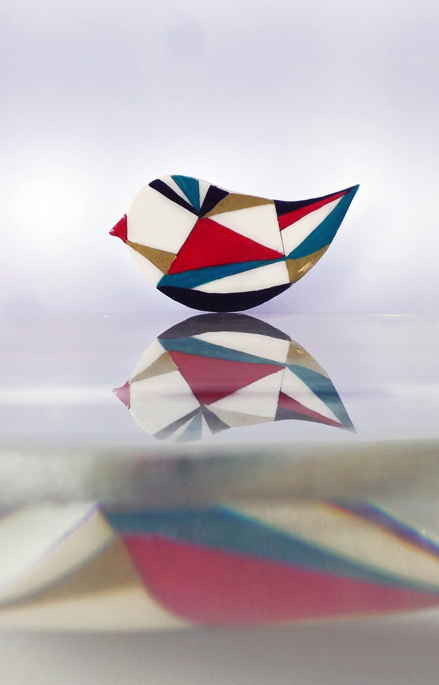 Broche de la colección Jazz de Lamai, un pájaro geométrico en rojo, azul y blanco
