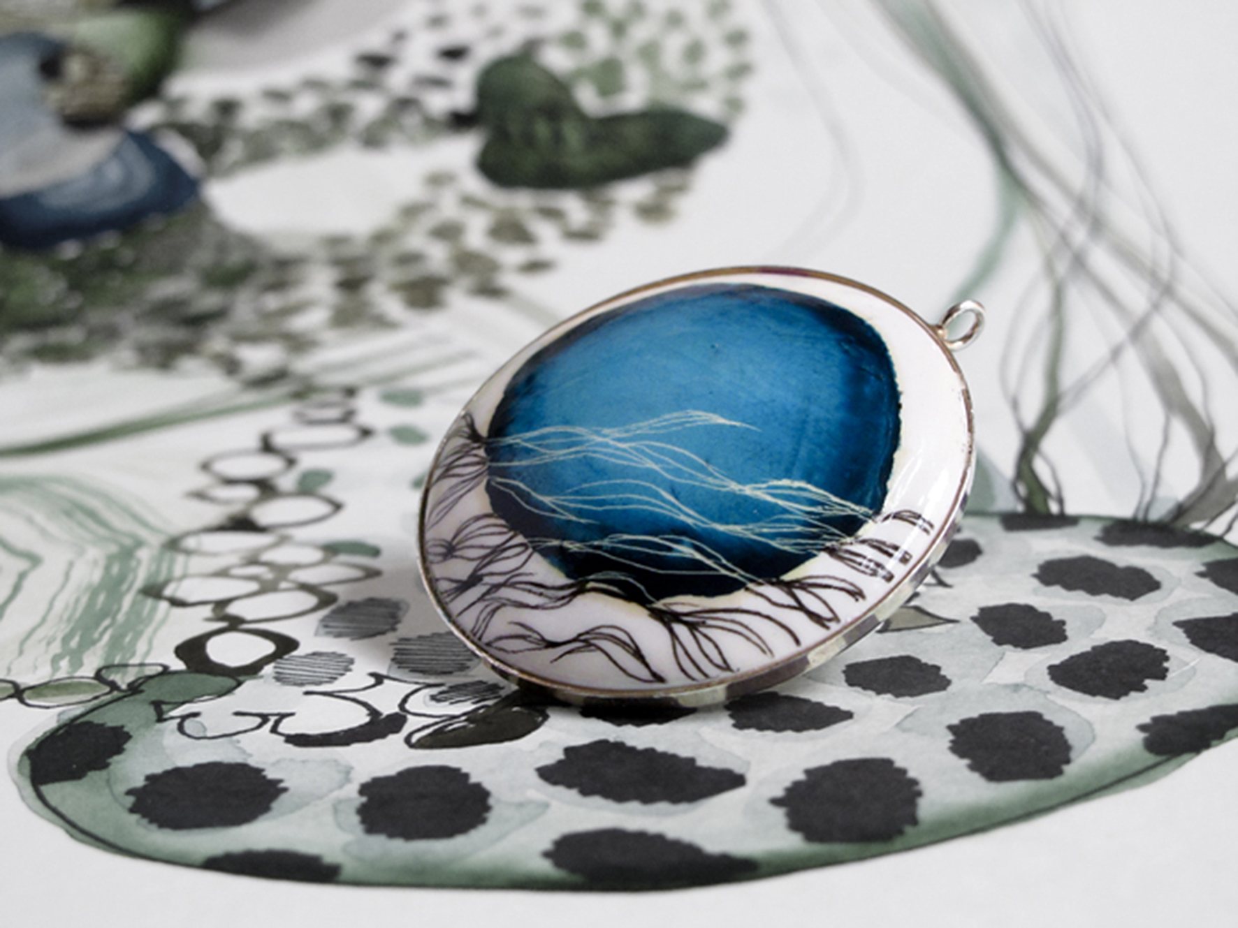 Colgante de la colección Sauce de Lamai, con un dibujo azul montado en plata