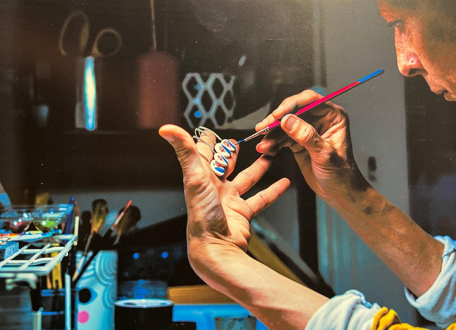 Una de las socias de Lamai pintando a mano unos pendientes con un pincel fino en el taller