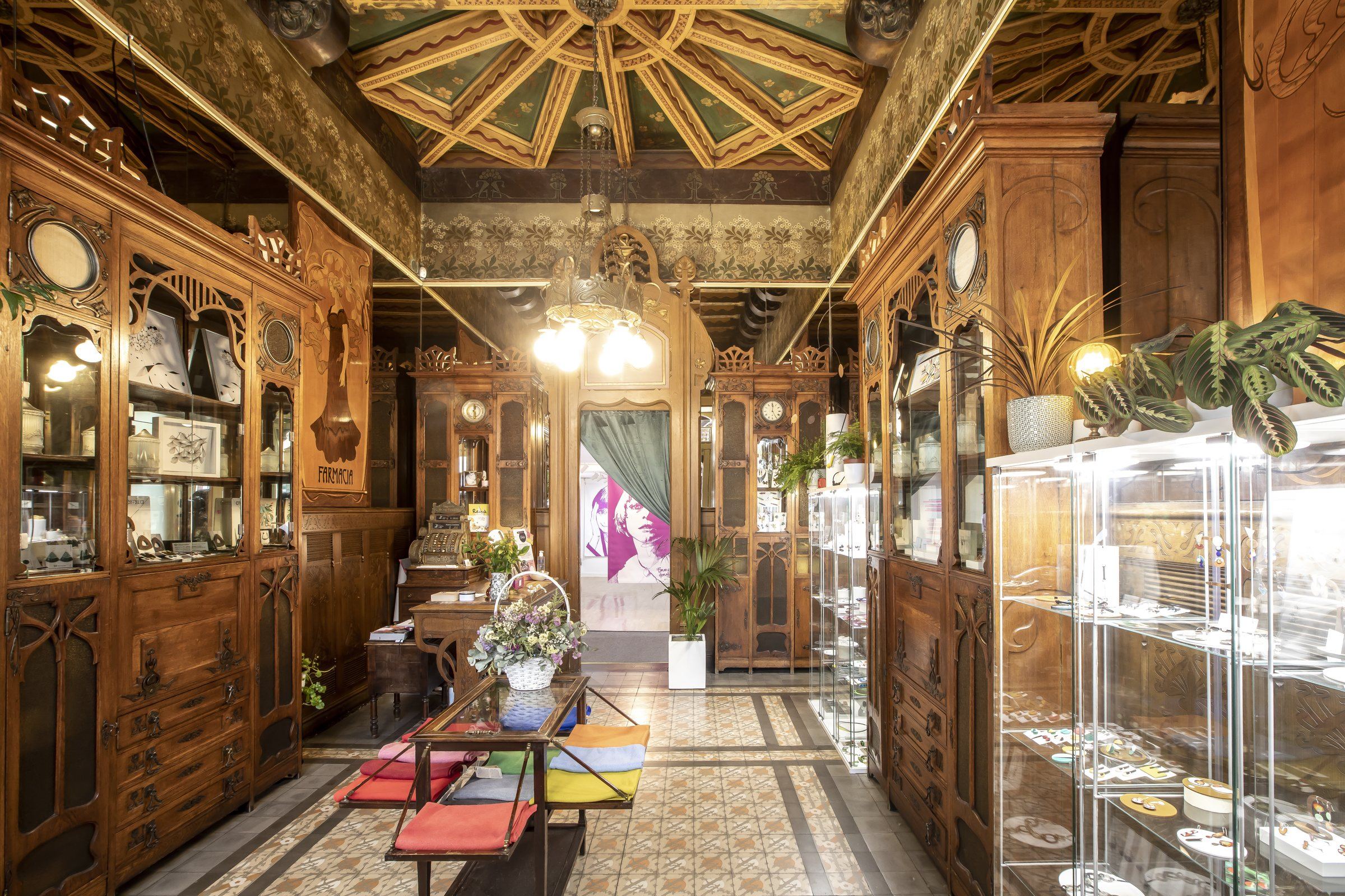 Interior de la tienda de Lamai: la galería de madera original de la farmacia, con el techo artesonado y las vitrinas de joyería